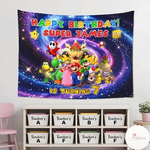 Peut inclure: Une tapisserie color&eacute;e repr&eacute;sentant des personnages de la s&eacute;rie de jeux vid&eacute;o Super Mario. La banni&egrave;re indique "Happy Birthday! Super James. Is Turning 7" sur un fond cosmique. La tapisserie est une d&eacute;coration vibrante pour une f&ecirc;te d'anniversaire.