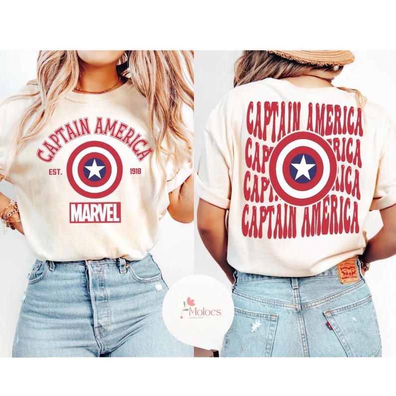 May include: Cream-colored t-shirt featuring the Captain America shield and text. The front displays the shield with "CAPTAIN AMERICA" and "MARVEL" text. The back repeats "CAPTAIN AMERICA" around the shield. A vintage-style design.