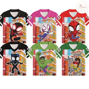 Puede incluir: Seis camisetas gr&aacute;ficas coloridas con varios personajes de Spider-Man. Cada camiseta tiene una combinaci&oacute;n de colores diferente, incluyendo negro, rosa y rojo, con un dise&ntilde;o de cuello en V y un gr&aacute;fico de edificio en el fondo.