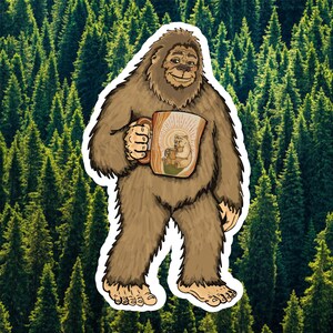 May include: A sticker featuring a brown, furry Bigfoot creature standing upright. The creature holds a tan mug decorated with an illustration of a bear drinking from a smaller mug, surrounded by radiating lines against a forest background.