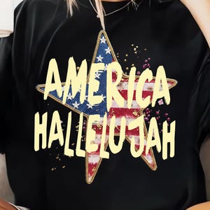 Pu&ograve; includere: T-shirt nera con un design a stella e la scritta "AMERICA HALLELUJAH". La stella incorpora il design della bandiera americana, con stelle blu e bianche e strisce rosse e bianche. Il testo &egrave; in giallo in grassetto.