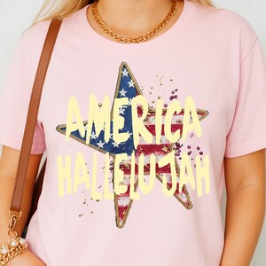 Pu&ograve; includere: T-shirt rosa chiaro con un design a stella con i colori della bandiera americana e la scritta gialla "AMERICA HALLELUJAH". La maglietta ha scollo tondo e maniche corte.