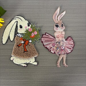 Blumenkaninchen Aufnäher, Hand hält Blumenkaninchen und Kaninchenaufnäher mit Rocknähaufnäher