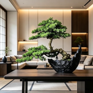 May include: A bonsai tree with vibrant green foliage and a textured, gnarled brown trunk. The tree is planted in a black, irregularly shaped, rock-like container with a rough surface, positioned on a dark wooden table surface.