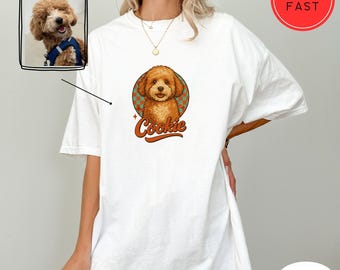 May include: White oversized t-shirt with a cartoon illustration of a brown poodle with the word "Cookie" in a retro font.