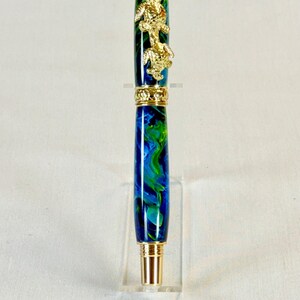 The Sea Turtle Roller Ball pen features a stunning blue-ocean synthetic Fire Opal, turtle shell texture, and sea turtle clip. Truly a turtle lover gift. It comes either as a Rollerball or Fountain Pen. The cap posts securely with wide threads that won't cross. Hawaiian Honu Pen that has beautiful ocean themed features. One of my favorite Sea Creatures is the Sea Turtle. This Pen has it all. The pen comes with a windowed pen box making this item gift-ready.