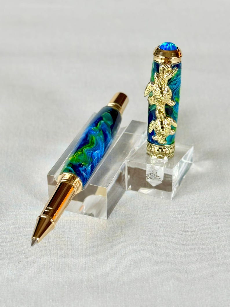 The Sea Turtle Roller Ball pen features a stunning blue-ocean synthetic Fire Opal, turtle shell texture, and sea turtle clip. Truly a turtle lover gift. It comes either as a Rollerball or Fountain Pen. The cap posts securely with wide threads that won't cross. Hawaiian Honu Pen that has beautiful ocean themed features. One of my favorite Sea Creatures is the Sea Turtle. This Pen has it all. The pen comes with a windowed pen box making this item gift-ready.