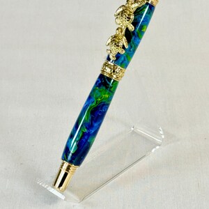The Sea Turtle Roller Ball pen features a stunning blue-ocean synthetic Fire Opal, turtle shell texture, and sea turtle clip. Truly a turtle lover gift. It comes either as a Rollerball or Fountain Pen. The cap posts securely with wide threads that won't cross. Hawaiian Honu Pen that has beautiful ocean themed features. One of my favorite Sea Creatures is the Sea Turtle. This Pen has it all. The pen comes with a windowed pen box making this item gift-ready.