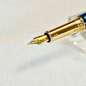 The Sea Turtle Roller Ball pen features a stunning blue-ocean synthetic Fire Opal, turtle shell texture, and sea turtle clip. Truly a turtle lover gift. It comes either as a Rollerball or Fountain Pen. The cap posts securely with wide threads that won't cross. Hawaiian Honu Pen that has beautiful ocean themed features. One of my favorite Sea Creatures is the Sea Turtle. This Pen has it all. The pen comes with a windowed pen box making this item gift-ready.