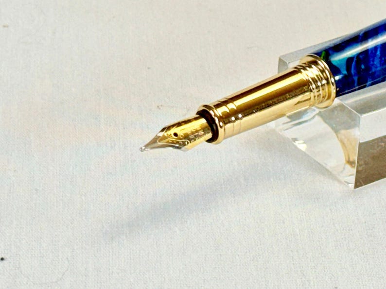 The Sea Turtle Roller Ball pen features a stunning blue-ocean synthetic Fire Opal, turtle shell texture, and sea turtle clip. Truly a turtle lover gift. It comes either as a Rollerball or Fountain Pen. The cap posts securely with wide threads that won't cross. Hawaiian Honu Pen that has beautiful ocean themed features. One of my favorite Sea Creatures is the Sea Turtle. This Pen has it all. The pen comes with a windowed pen box making this item gift-ready.