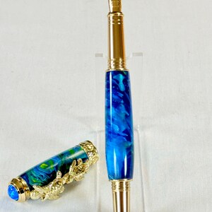 The Sea Turtle Roller Ball pen features a stunning blue-ocean synthetic Fire Opal, turtle shell texture, and sea turtle clip. Truly a turtle lover gift. It comes either as a Rollerball or Fountain Pen. The cap posts securely with wide threads that won't cross. Hawaiian Honu Pen that has beautiful ocean themed features. One of my favorite Sea Creatures is the Sea Turtle. This Pen has it all. The pen comes with a windowed pen box making this item gift-ready.