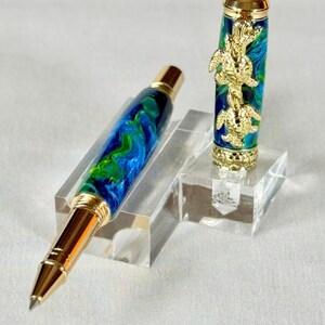The Sea Turtle Roller Ball pen features a stunning blue-ocean synthetic Fire Opal, turtle shell texture, and sea turtle clip. Truly a turtle lover gift. It comes either as a Rollerball or Fountain Pen. The cap posts securely with wide threads that won't cross. Hawaiian Honu Pen that has beautiful ocean themed features. One of my favorite Sea Creatures is the Sea Turtle. This Pen has it all. The pen comes with a windowed pen box making this item gift-ready.