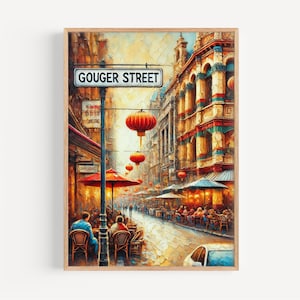May include: A framed art print of Gouger Street, depicting a vibrant street scene with red lanterns, outdoor seating, and a sign. The artwork features a warm color palette with impressionistic brushstrokes, capturing the essence of a bustling city street.