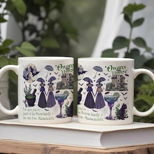 May include: A white ceramic mug featuring a colorful illustration of two figures in purple dresses holding umbrellas, a large house labeled Owens House, a mortar and pestle, a margarita, and a black cat. Text reads: I'm sure you've heard of the Owens family.