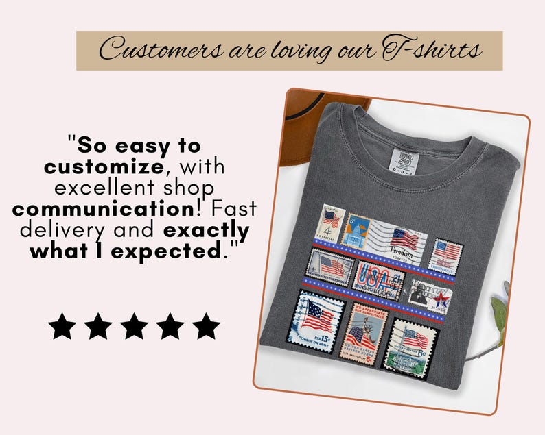 May include: A dark gray t-shirt featuring a design of vintage American postage stamps with US flags. The shirt includes the text "Customers are loving our T-shirts" and a customer review. The shirt is folded on a white surface.