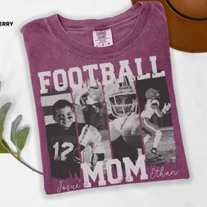 May include: Berry-colored t-shirt with the words "FOOTBALL MOM" in white block letters. The shirt features black and white photos of football players. The name "Ethan" is written in script below the words "FOOTBALL MOM". The word "Berry" is in the upper left corner.