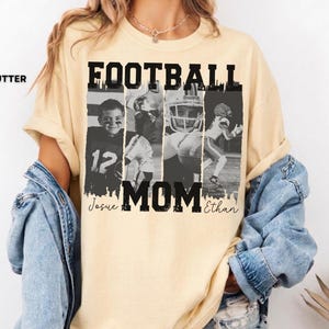 May include: Butter-colored t-shirt with the text "FOOTBALL MOM" in black block letters. The shirt features a collage of black and white photos of football players. The names "Josue" and "Ethan" are printed below the word "MOM".