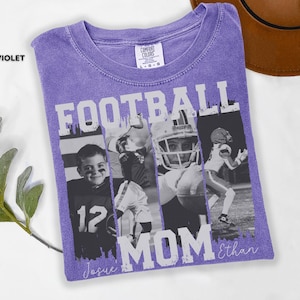 May include: A violet Comfort Colors t-shirt with a football theme. The shirt features the word "FOOTBALL MOM" in white block letters, along with black and white photos of football players. The names "Josue" and "Ethan" are written in script.