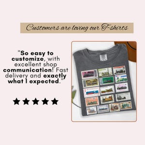 May include: A gray t-shirt featuring a collection of vintage postage stamps with train illustrations. The shirt has a crew neck and short sleeves. Text on the image reads "Customers are loving our T-shirts" and a customer review.