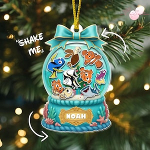 May include: A blue and turquoise snow globe ornament featuring various cartoon fish characters. The ornament has a bow at the top and the name "Noah" on the base. The text "Shake Me" is also present.