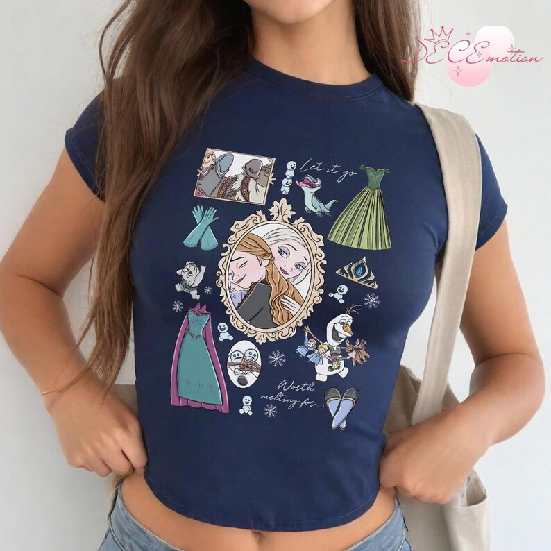 May include: Navy blue crop top featuring a collage of images from the animated film "Frozen." The design includes illustrations of characters, dresses, and the text "Let it go" and "Worth melting for."