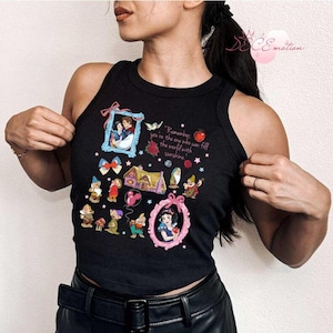 Pode incluir: Top preto sem mangas, estilo cropped, com estampa gr&aacute;fica dos personagens de Branca de Neve e os Sete An&otilde;es. O texto "Remember you're the one who can fill the world with sunshine" est&aacute; impresso na camiseta.