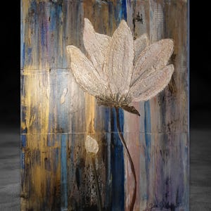Könnte beinhalten: Eine weiße Blume mit einer strukturierten Oberfläche ist auf einem Hintergrund aus goldenen, blauen und braunen vertikalen Streifen gemalt. Die Blume befindet sich in der Mitte des Gemäldes und ist der Hauptfokus. Der Hintergrund ist abstrakt und hat eine strukturierte Optik. Das Gemälde ist unten rechts signiert.