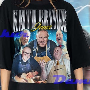 Puede incluir: Camiseta negra con un gráfico de Keith Brymer Jones y el texto "Keith Brymer Jones". El gráfico incluye múltiples imágenes de la personalidad televisiva. La camiseta la lleva una persona.