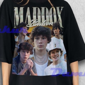 May include: Black oversized t-shirt featuring a collage of images and the text "MADDOX Batson" in a vintage style. The shirt has a crew neck and short sleeves. The graphic includes multiple images of a young man.