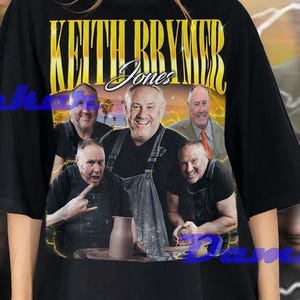 Puede incluir: Camiseta negra de gran tamaño con un gráfico de Keith Brymer Jones y el texto "Keith Brymer Jones". El diseño incluye múltiples imágenes de la persona en un estilo vintage con un fondo amarillo y blanco.