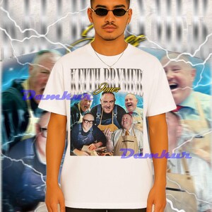 May include: White t-shirt featuring a graphic of a group of men with the text "KEITH DDVME" and "Jones". The shirt is worn by a person wearing sunglasses.