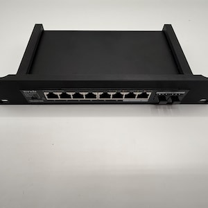 Könnte beinhalten: Schwarzer Netzwerk-Switch mit mehreren Anschlüssen. Das Gerät trägt den Markennamen "Tenda" auf der Vorderseite. Der Switch ist für die Rackmontage konzipiert und hat ein schlankes, modernes Design.