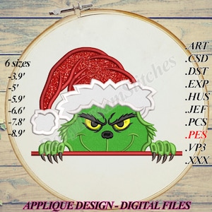 May include: An embroidery hoop featuring a green character wearing a red Santa hat with white trim. The character has a mischievous expression with yellow eyes and is holding a red bar. Text includes "6 sizes" and "APPLIQUE DESIGN - DIGITAL FILES".
