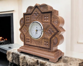 Puede incluir: Un reloj de madera con un diseño geométrico intrincado. La esfera del reloj es blanca con números y manecillas negras. El reloj es marrón y se asienta sobre una base de madera. El reloj mide aproximadamente 30 cm de alto.