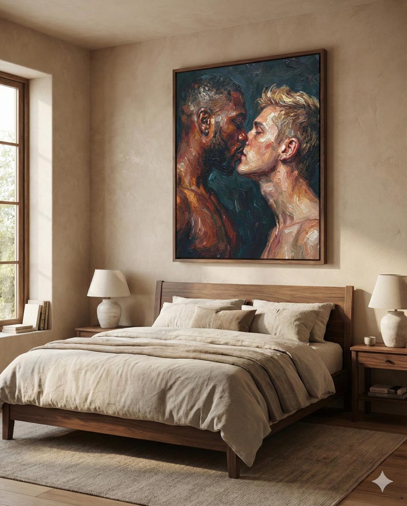 May include: A bedroom scene featuring a large framed painting of two men kissing, above a wooden bed with beige bedding. Two matching bedside tables with lamps flank the bed. The room has a neutral color palette with natural light.