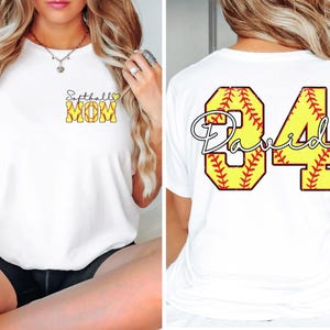 Puede incluir: Camiseta blanca con "Softball MOM" en texto amarillo y negro en la parte delantera. La parte trasera de la camiseta presenta el nombre "David" y el n&uacute;mero "84" en un dise&ntilde;o de softbol.