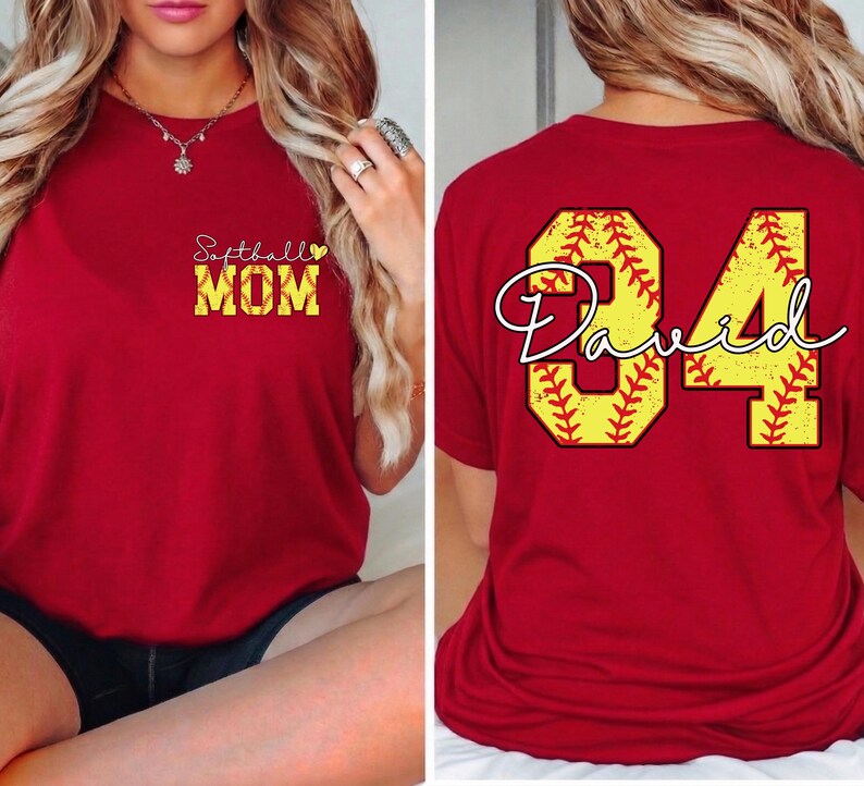 Puede incluir: Camiseta roja con "Softball MOM" en amarillo y blanco en la parte delantera. La parte trasera presenta un dise&ntilde;o de b&eacute;isbol amarillo con el nombre "David" y el n&uacute;mero "84".