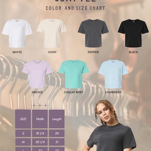 May include: A color chart for Comfort Colors Boxy Tee shirts. The chart displays shirts in white, ivory, pepper, black, orchid, chalky mint, and chambray. A size chart shows measurements in inches for sizes S to XXL.