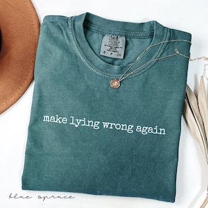 May include: A dark green t-shirt with the text "make lying wrong again" in white lettering. The shirt is made of a soft, comfortable fabric and has a relaxed fit.