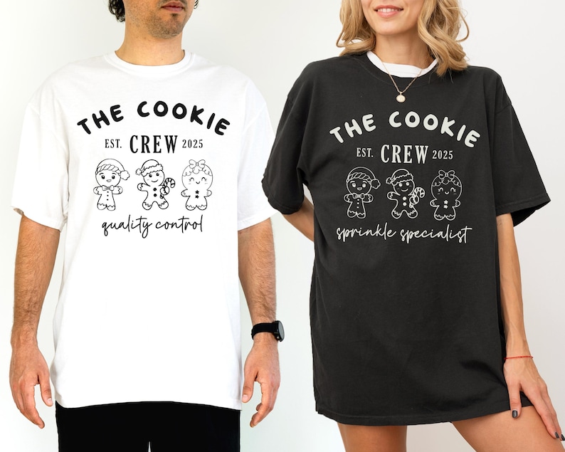 May include: Two t-shirts, one white and one black, featuring the text "THE COOKIE CREW EST. 2025" above three gingerbread people illustrations. The white shirt says "quality control" below the illustrations, while the black shirt says "sprinkle specialist".