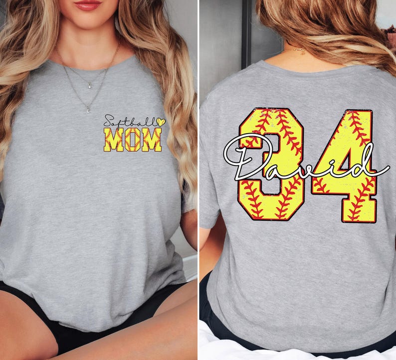 Puede incluir: Una camiseta gris claro con las palabras "Softball MOM" en amarillo y negro en la parte delantera. La parte trasera de la camiseta presenta el n&uacute;mero "84" en amarillo con un dise&ntilde;o de softbol y el nombre "David" en blanco.