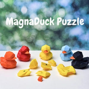 May include: A collection of geometric duck puzzles in various colors, including orange, red, yellow, blue, and black. The text "MagnaDuck Puzzle" is displayed in white. Some puzzles are assembled, while others are disassembled into pieces.