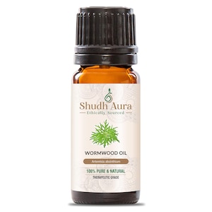 May include: A brown glass bottle of wormwood oil with a black cap. The label reads "Shudh Aura - Ethically Sourced" and "Wormwood Oil" with "100% Pure & Natural" and "Therapeutic Grade" text. The bottle contains a clear, amber-coloured liquid.