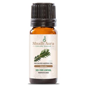 Può includere: Una bottiglia di vetro marrone di olio di abete argentato Shudh Aura. L'etichetta presenta un'illustrazione di ramo di abete verde e il testo "100% Pure & Natural Therapeutic Grade". La bottiglia ha un tappo nero.