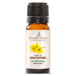 Peut inclure: Une bouteille en verre brun d'huile de Cassia avec un bouchon noir. L'étiquette est blanche avec du texte vert et un motif de fleur jaune. Le texte sur l'étiquette indique "Shudh Aura Ethically Sourced Cassia Oil Cassia fistula 100% PURE & NATURAL THERAPEUTIC GRADE".