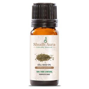 May include: A brown glass bottle of Shudh Aura Dill Seed Oil. The label includes the text "Ethically Sourced", "100% Pure & Natural", and "Therapeutic Grade". The bottle has a black cap and contains dill seeds.