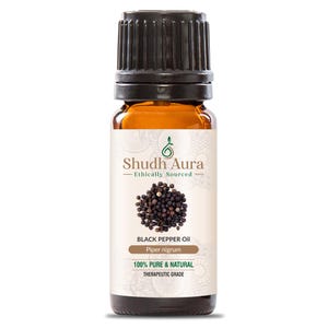 May include: A brown glass bottle with a black cap, labeled "Shudh Aura - Ethically Sourced" and "BLACK PEPPER Oil - Piper nigrum - 100% PURE & NATURAL - THERAPEUTIC GRADE". The bottle contains black peppercorns.
