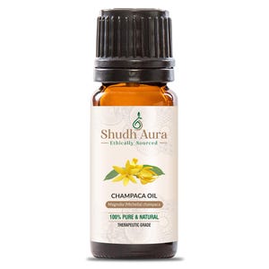 Op de afbeelding: Een klein amberkleurig glazen flesje met een zwarte dop, met het label "Shudh Aura Ethically Sourced Champaca Oil Magnolia (Michelia) champaca 100% PURE & NATURAL THERAPEUTIC GRADE".