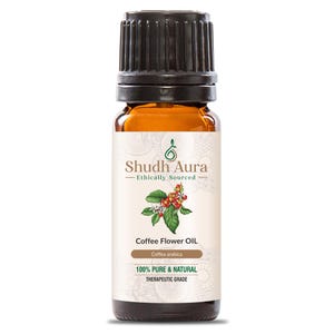 以下が含まれることがあります： 黒いキャップが付いた、コーヒーフラワーオイルの茶色のガラス瓶。「Shudh Aura - Ethically Sourced」と「100% Pure & Natural Therapeutic Grade」と書かれたラベル。ラベルには、コーヒーの葉とベリーのイラストも描かれています。