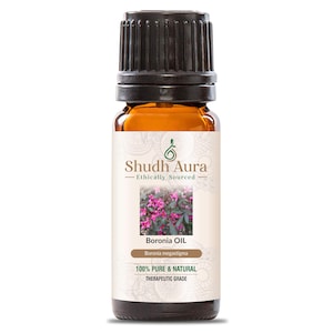 Puede incluir: Una peque&ntilde;a botella de vidrio &aacute;mbar de aceite de Boronia con una tapa negra. La etiqueta dice "Shudh Aura - Ethically Sourced" e incluye el texto "Boronia Oil" y "100% Pure & Natural Therapeutic Grade". Una foto de flores rosas est&aacute; en la etiqueta.